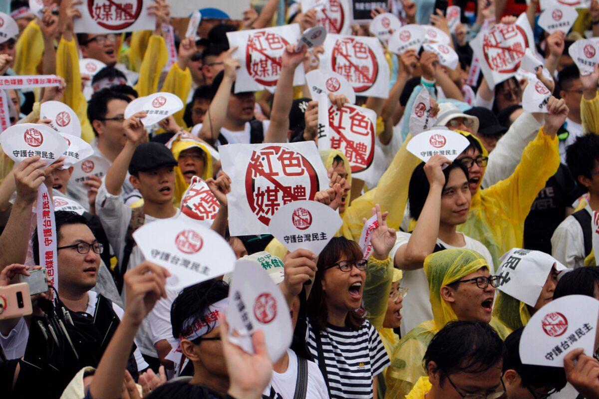 Protesters hold placards with messages that read “reject red media” and “safeguard the nation's democracy” during a rally against pro-China media in Taipei on June 23, 2019. (Hsu Tsun-hsu / AFP)