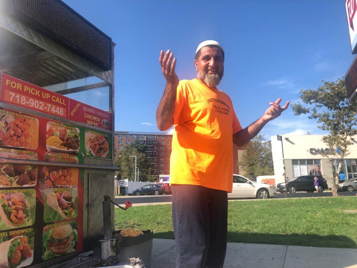 Salimi Popal working at his food cart in Flushing, Queens, on Aug. 30, 2021. (Enrico Trigoso/The Epoch Times)