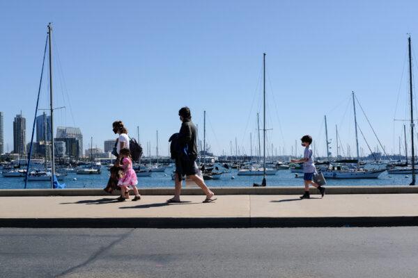 People walk along the sidewalk near the Port of San Diego, Calif., on March 27, 2021. (John Fredricks/The Epoch Times)