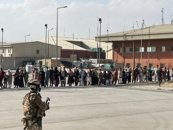 Afghan evacuees queue before boarding one of the last Italy's military aircraft C130J during evacuation at Kabul's airport, Afghanistan, on Aug. 27, 2021. (Italian Ministry of Defence/Handout via Reuters)