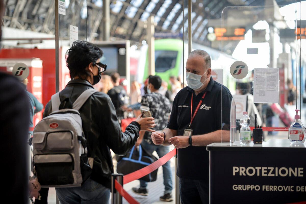 A passenger holds up his phone at a check point at Milan's Stazione Centrale train station, Italy, on Sept. 1, 2021. (Claudio Furlan/LaPresse via AP)