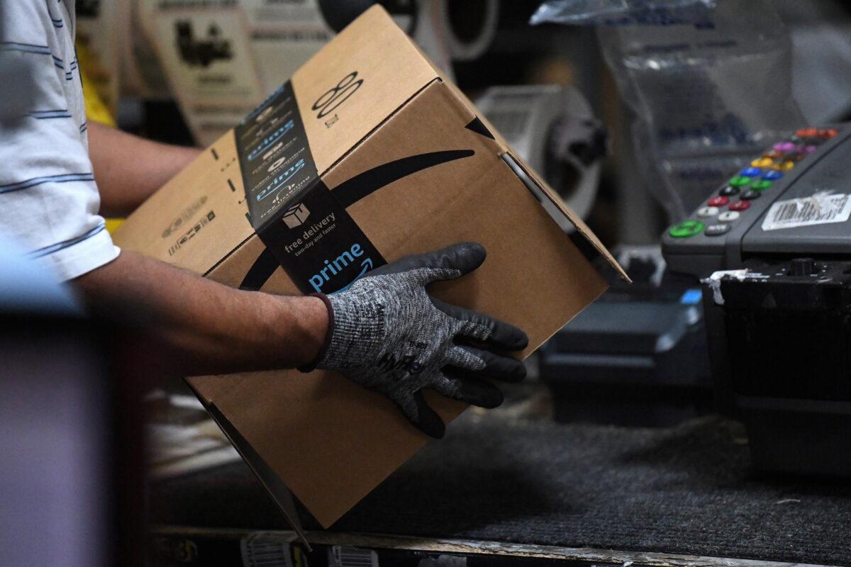 A worker assembles a box for delivery at the Amazon fulfillment center in Baltimore, on April 30, 2019. (Clodagh Kilcoyne/Reuters)