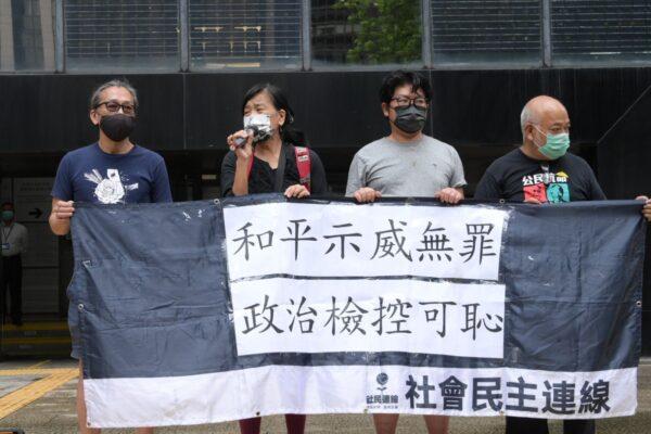 Chan Po-ying (L-2) and three other members from the League of Social Democrats held a banner that reads “peaceful demonstrations are innocent, shame to political prosecution” outside Wanchai Law Court in Hong Kong on Sep. 1, 2021. (Sung Pi-lung/The Epoch Times)