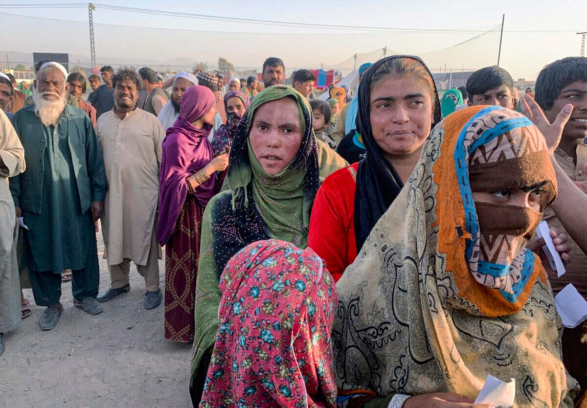 Afghan families gather to receive food stuff distributing by an Islamabad-based Christian organization on the outskirts of Chaman, a town in the Pakistan’s southwestern Baluchistan province, on the border with Afghanistan, on Aug. 31, 2021. (AP Photo)