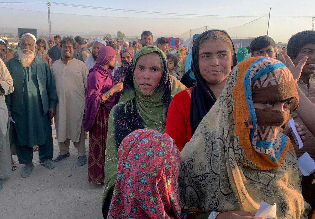 Afghan families gather to receive food distributed by an Islamabad-based Christian organization on the outskirts of Chaman, a town in Pakistan’s southwestern Baluchistan province, on the border with Afghanistan, on Aug. 31, 2021. Dozens of Afghan families have crossed into Pakistan through the southwestern Chaman border a day after the U.S. wrapped up its 20-year military presence in the Taliban-controlled country. (AP Photo)