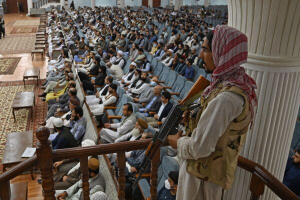 A Taliban fighter stands guard as the group's Higher Education Minister Abdul Baqi Haqqani speaks on the Taliban's higher education policies at the Loya Jirga Hall in Kabul on Aug. 29, 2021. (Aamir Qureshi/AFP via Getty Images)