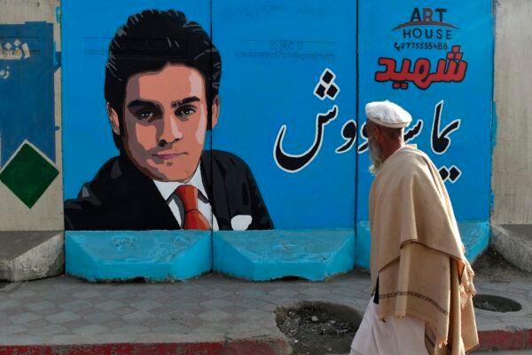 A man walks past a barrier wall on Jan. 19, 2021, painted with an image of former Afghan Tolo TV presenter Yama Siawash, who was killed in a targeted attack allegedly by the Taliban in Kabul on Nov. 7, 2020, amid the country's peace talks. (Wakil Kohsar/AFP via Getty Images)