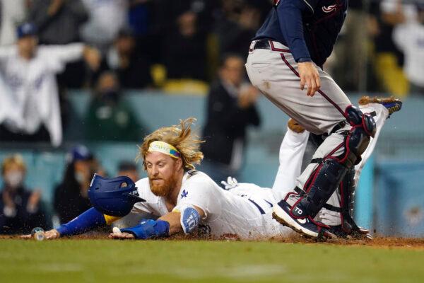 Los Angeles Dodgers' Justin Turner scores past Atlanta Braves catcher Travis d'Arnaud on a single by AJ Pollock during the eighth inning of a baseball game in Los Angeles on Sept. 1, 2021. (Marcio Jose Sanchez/AP Photo)