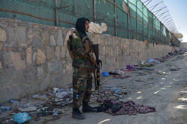 A Taliban fighter stands guard at the site of the Aug. 26 twin suicide bombs, which killed scores of people, including 13 U.S. troops, at Kabul airport in Afghanistan on Aug. 27, 2021. (Wakil Kohsar/AFP via Getty Images)