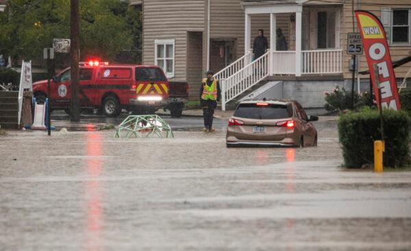 A car is stranded on a flooded street in Bridgeville, Pa., has the remnants of Hurricane Ida moved north on Sept. 1, 2021. (Andrew Rush/Pittsburgh Post-Gazette via AP)