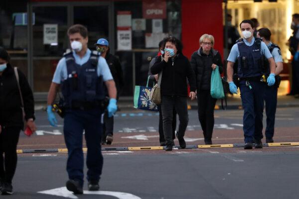 Police escort people from LynnMall to their cars after a violent extremist stabbed six people before being shot by police in Auckland, New Zealand, on Sept. 3, 2021. (Fiona Goodall/Getty Images)
