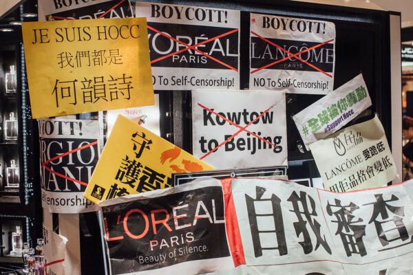 Protesters hold placards and shout slogans as they take part in a rally against French cosmetics brand Lancome in the Causeway Bay district, Hong Kong, on June 8, 2016. (Anthony Kwan/Getty Images)
