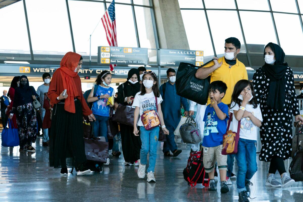 Families evacuated from Kabul, Afghanistan, walk through the terminal before boarding a bus after they arrived at Washington Dulles International Airport, in Chantilly, Va., on Sept. 2, 2021. (Jose Luis Magana/AP Photo)