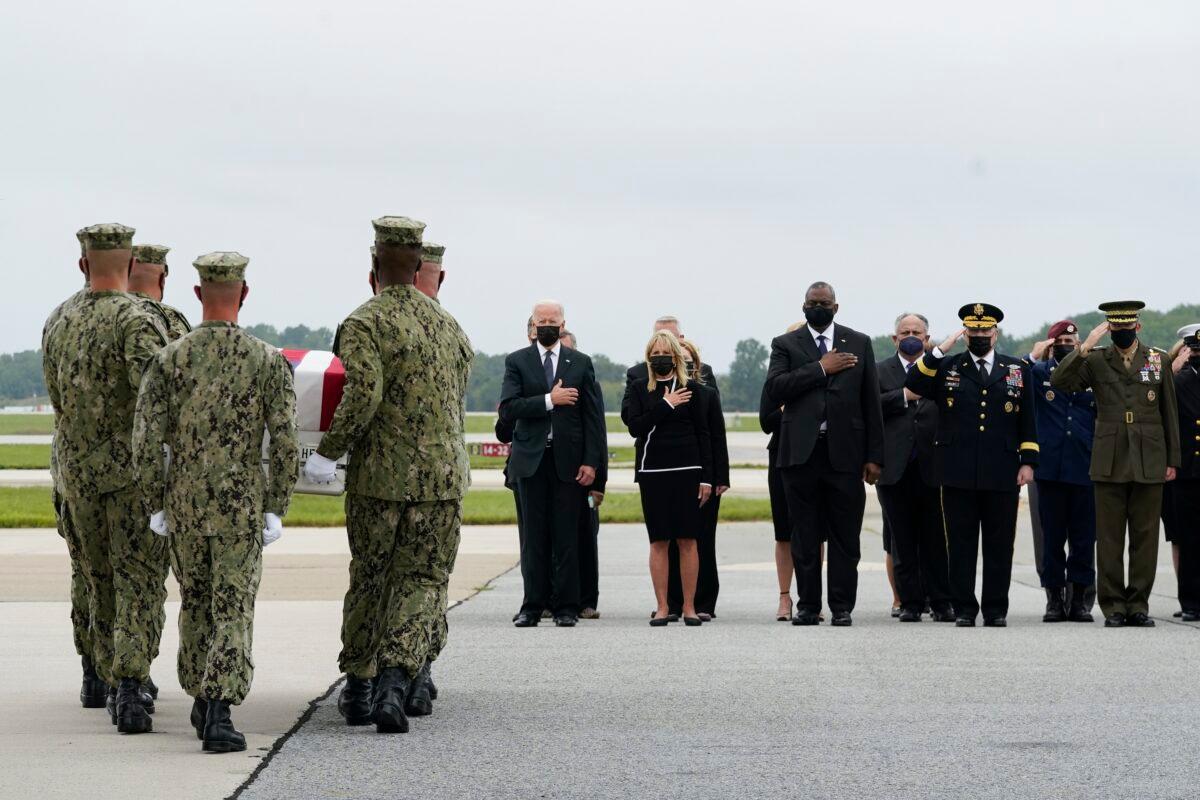 President Joe Biden watches as a Navy carry team moves a transfer case containing the remains of Navy Corpsman Maxton W. Soviak, 22, of Berlin Heights, Ohio, at Dover Air Force Base in Dover, Del., on Aug. 29, 2021. (Manuel Balce Ceneta/AP Photo)