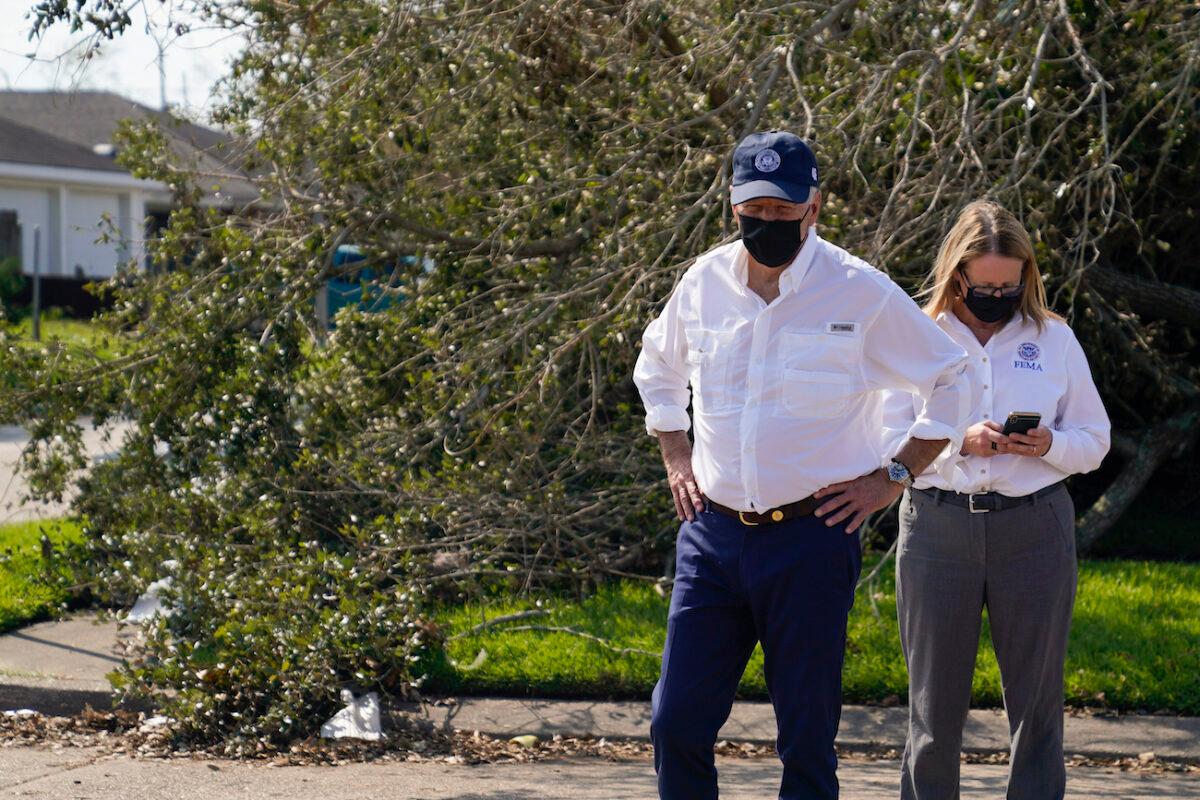 President Joe Biden pauses as he tours a neighborhood impacted by Hurricane Ida, as Federal Emergency Management Agency Administrator Deanne Criswell checks her phone, in LaPlace, La., on Sept. 3, 2021. (Evan Vucci/AP Photo)