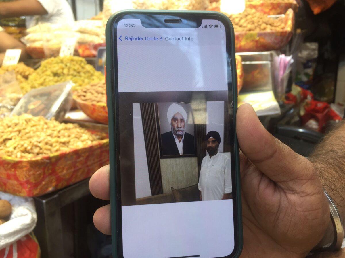 Pawan Deep Singh shows the picture of his father and grandfather on his mobile phone at Khari Bouli market in old Delhi on Sept. 3, 2021. They fled from Kabul 40 years ago. (Venus Upadhayaya/Epoch Times)