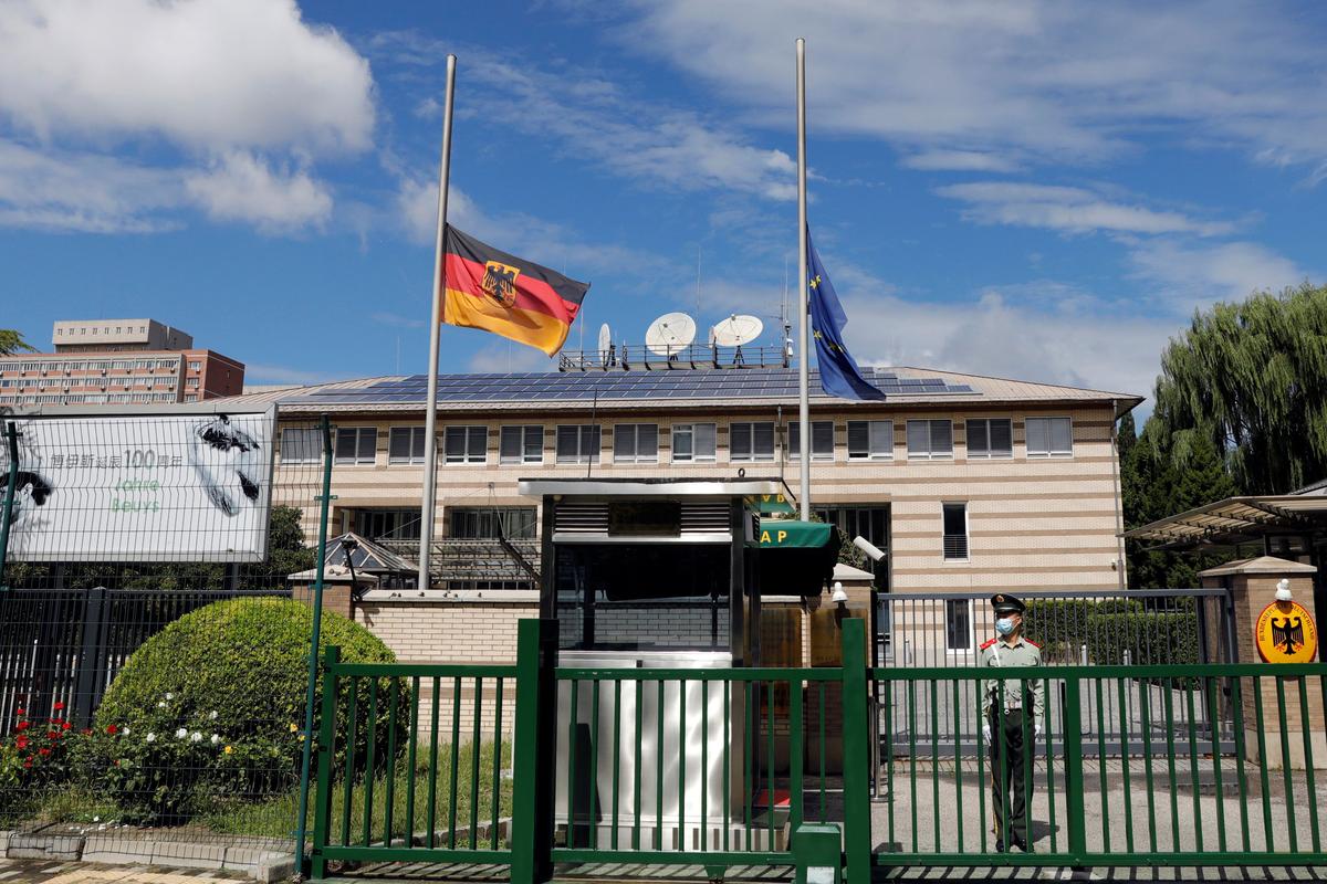 The German and European Union flags fly at half-staff after the death of Germany's ambassador to China, Jan Hecker, at the German Embassy in Beijing on Sept. 6, 2021. (Carlos Garcia Rawlins/Reuters)