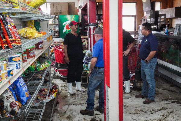 Piggly Wiggly owner Taddese Tewelde speaks with insurance representatives inside his store, which was flooded by Hurricane Ida, in Jefferson Parish, La., on Sept. 4, 2021. (Jackson Elliott/The Epoch Times)