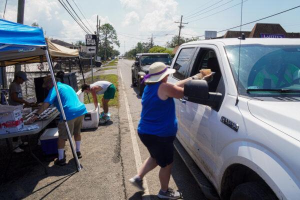 A woman distributes food in Jefferson Parish, La., on Sept. 4, 2021. (Jackson Elliott/The Epoch Times)