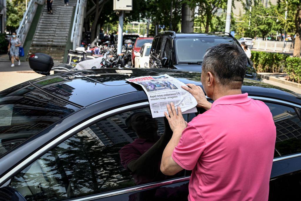 A man reads the Chinese state-run newspaper Global Times with coverage of the Taliban's military takeover in Afghanistan, on a street in Beijing on Aug. 17, 2021. (Jade Gao/AFP via Getty Images)