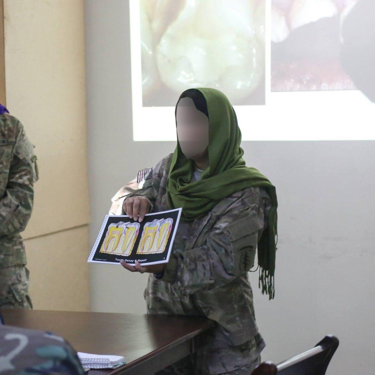 Interpreter at work in Afghanistan, with face blurred to protect her identity. (Courtesy of the interpreter)