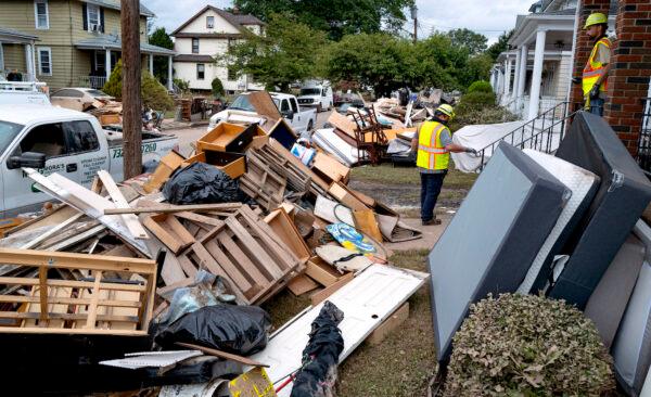 Utility workers work among debris from flood damage caused by the remnants of Hurricane Ida in Manville, N.J., Sept. 5, 2021. (AP Photo/Craig Ruttle)