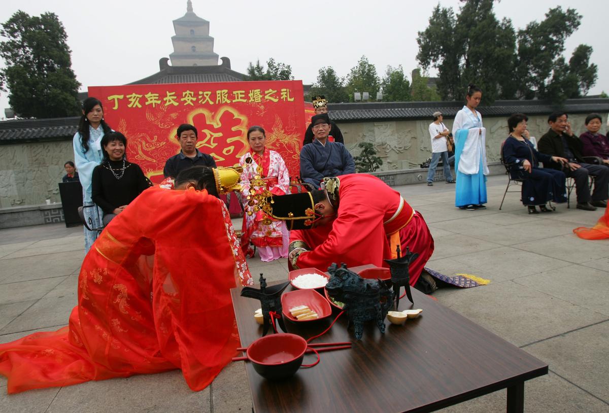 A newly wed couple exchanges bows during a Han-style collective wedding ceremony at the north plaza of the Big Wild Goose Pagoda on Oct. 3, 2007, in Xian of Shaanxi Province, China. (China Photos/Getty Images)