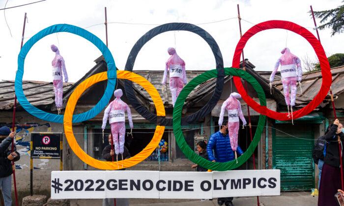 Exiled Tibetans use the Olympic Rings as a prop as they hold a street protest against the holding of 2022 Winter Olympics in Beijing, in Dharmsala, India, on Feb. 3, 2021. (Ashwini Bhatia/AP Photo)