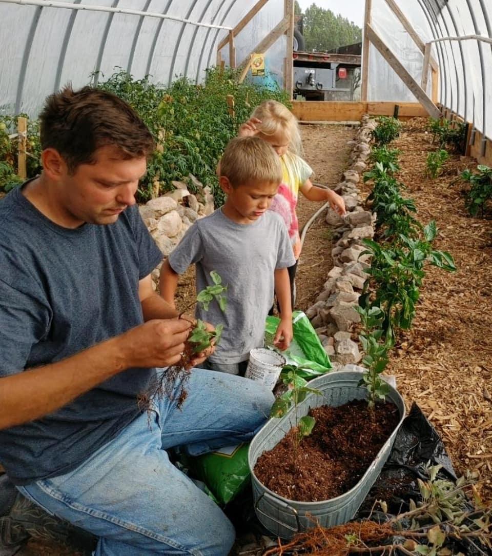 Chris with children tending to their plants. (Courtesy of <a href="https://www.instagram.com/littlehouseinthehighdesert/">Courtney Rogers</a>)