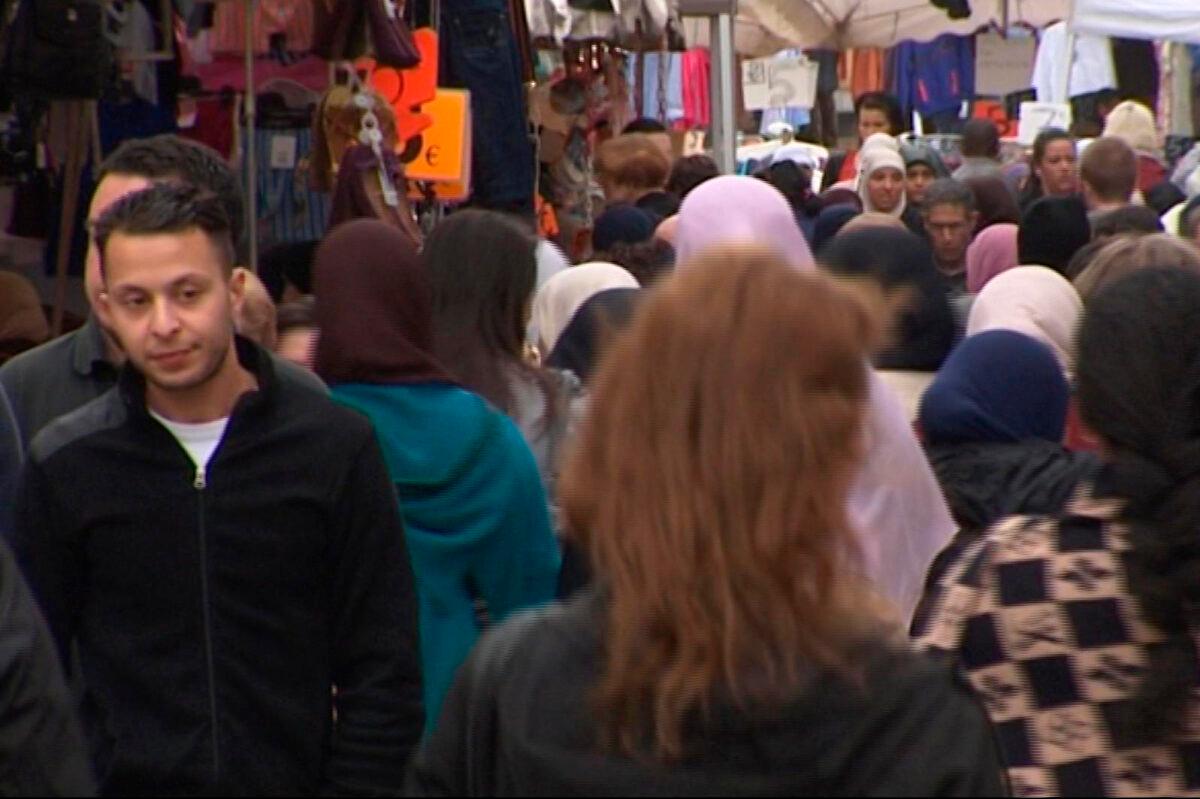 Salah Abdeslam, left, strolling through the Molenbeek market in Brussels, on April 13, 2016. (Bruzz via AP/File)