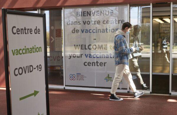 A man walks past a sign at a COVID-19 vaccination center in Geneva, Switzerland, on April 15, 2021. (Denis Balibouse/Reuters)