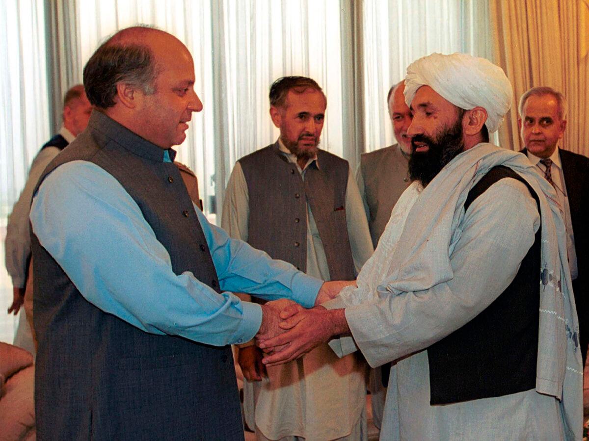 Mullah Hasan Akhund (R), then Afghanistan's foreign minister, is received by then-Pakistan Prime Minister Nawaz Sharif in Islamabad on Aug. 25, 1999. (B.K. Bangash/AP Photo)