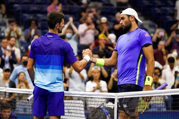 Novak Djokovic (L) of Serbia shakes hands with Matteo Berrettini of Italy after Djokovic's win during the quarterfinals of the U.S. Open tennis tournament in New York on Sept. 9, 2021. (Frank Franklin II/AP Photo)