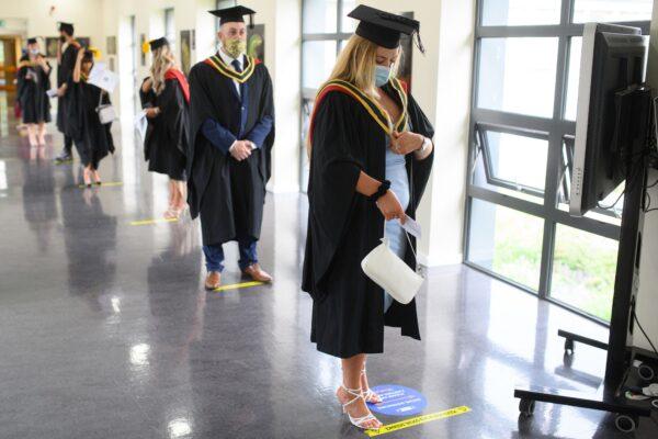 Graduates queue on campus at the University of Bolton as they wait to receive their degree certificates in Bolton, northwest England, on July 9, 2021. (Oli Scarff/AFP via Getty Images)