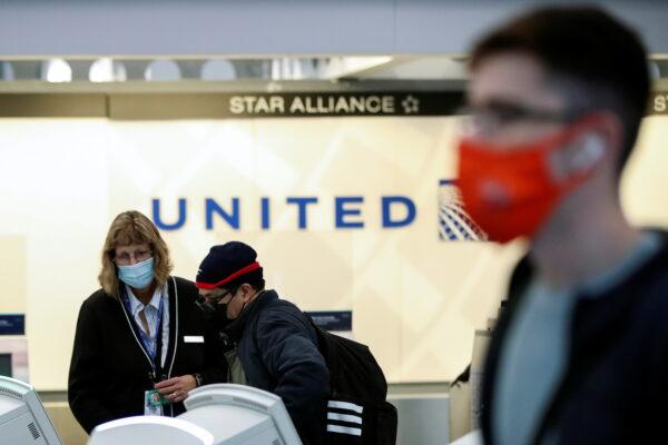 A United Airlines agent helps a customer check in for his flight at O'Hare International Airport in Chicago, Ill., on Nov. 25, 2020. (Kamil Krzaczynski/Reuters)