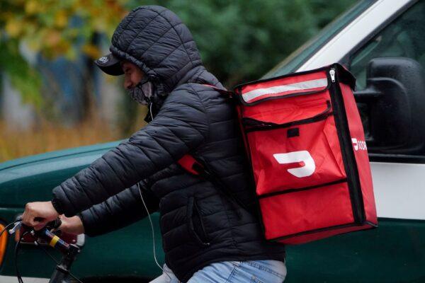 A delivery person for Doordash rides his bike in the rain during the COVID-19 pandemic in New York City, on Nov. 13, 2020. (Carlo Allegri/Reuters)