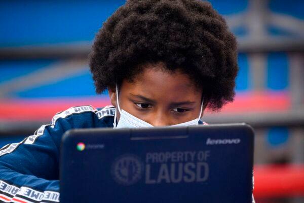  A child wears a face mask as they attend an online class at a learning hub inside the Crenshaw Family YMCA during the Covid-19 pandemic in Los Angeles, Calif., on Feb. 17, 2021. (Patrick T. Fallon/AFP via Getty Images)