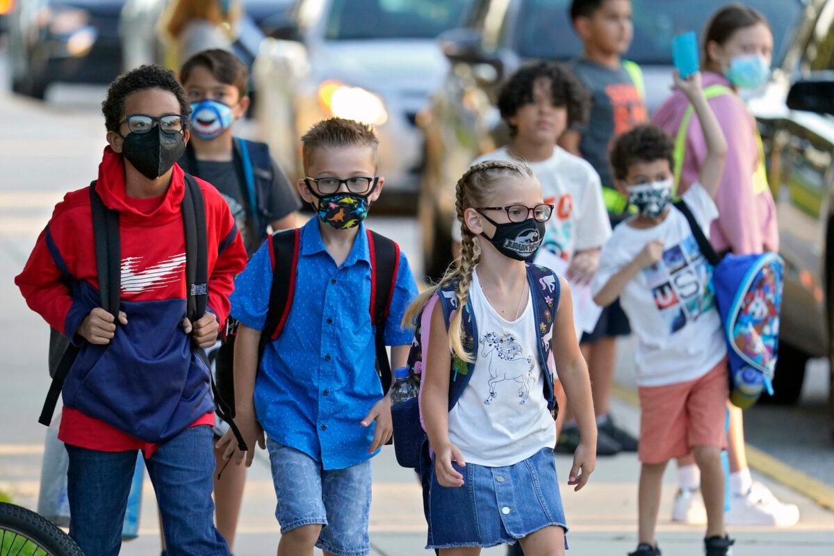 Students, some wearing protective masks, arrive for the first day of school at Sessums Elementary School in Riverview, Fla., on Aug. 10, 2021. (Chris O'Meara/AP Photo)