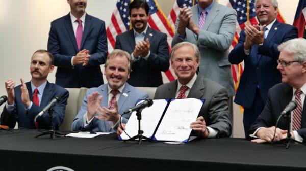  Texas Gov. Greg Abbott (3R) signs Senate Bill 1, also known as the election integrity bill into law with others clapping and looking on in Tyler, Texas, on Sept. 7, 2021. (Marina Fatina/NTD)