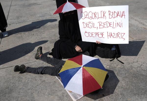 A woman holds a placard reading, "Freedom is not free. We are ready to pay for it," during a protest against official COVID-19-related mandates including vaccinations, tests, and masks, in Istanbul, on Sept. 11, 2021. (Murad Sezer/Reuters)