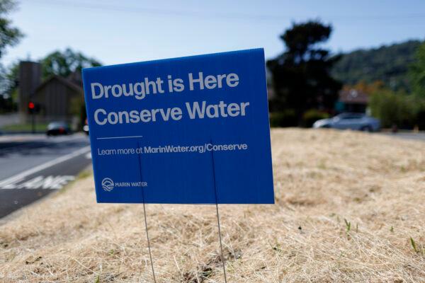 A sign advocating water conservation is posted in a field of dry grass in San Anselmo, Calif., on April 23, 2021. (Justin Sullivan/Getty Images)
