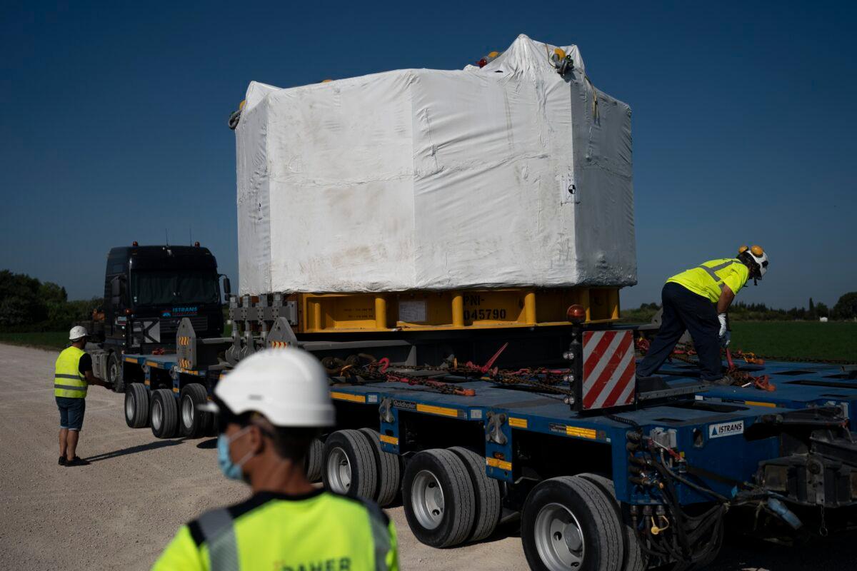Workers secure a central solenoid magnet for the ITER project as it departs from Berre-l'Etang in southern France, on Sept. 6, 2021. (Daniel Cole/AP Photo)
