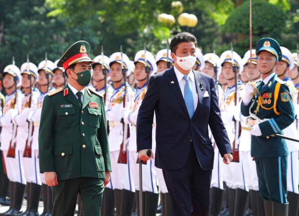 Vietnamese Defense Minister Phan Van Giang (L) and Japanese Defense Minister Nobuo Kishi review honor guards in Hanoi, Vietnam, on Sept. 12, 2021. (Nguyen Trong Duc/VNA via AP)