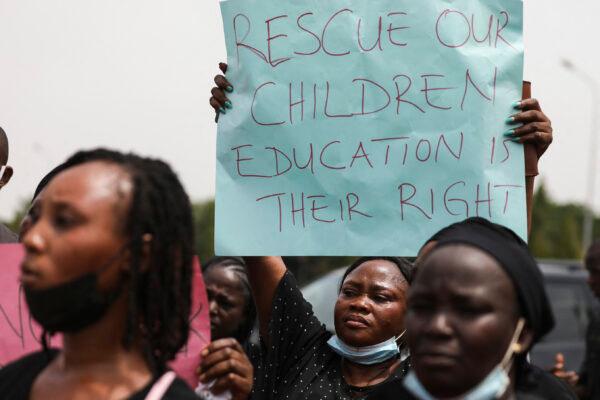 Parents and relatives of students from the Federal College of Forestry Mechanization in Kaduna who have been abducted, hold placards during a demonstration in Abuja, Nigeria, on May 4, 2021. (Kola Sulaimon/AFP via Getty Images)