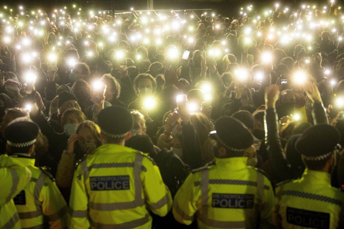 Members of the crowd shine lights from their phones at the vigil for Sarah Everard in Clapham Common, London, on March 13, 2021. (Victoria Jones/PA)