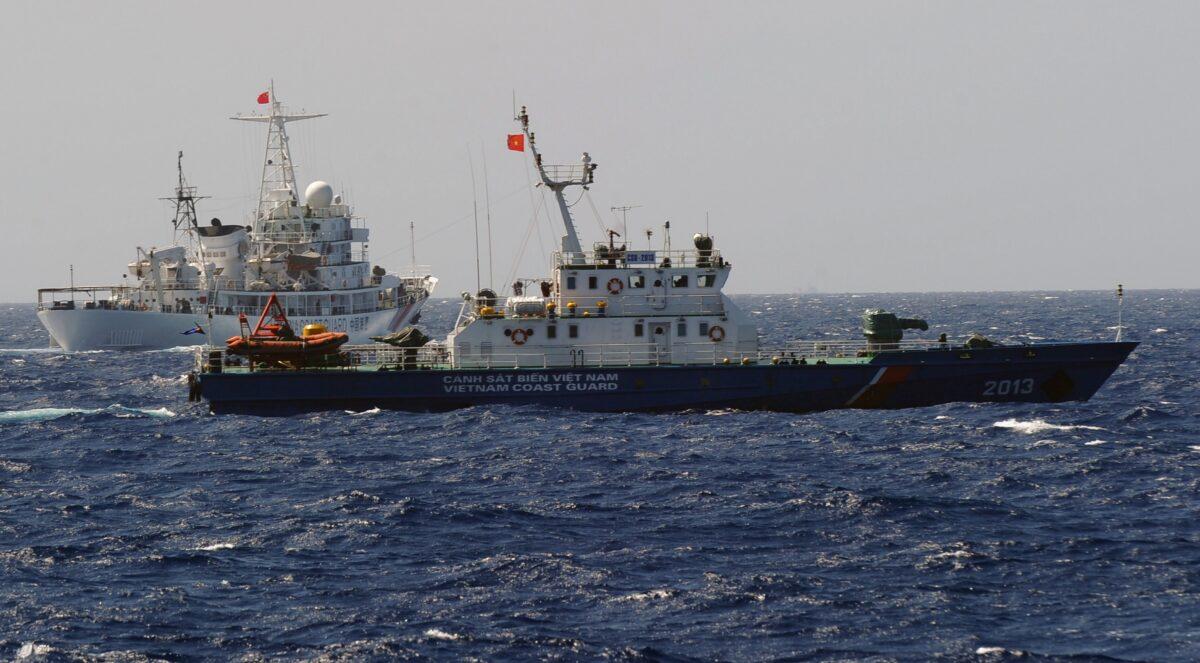 A China Coast Guard ship (L) chases a Vietnam Coast Guard vessel near the site of a Chinese drilling oil rig being installed at the disputed water in the South China Sea off Vietnam's central coast on May 14, 2014. (Hoang Dinh Nam/AFP via Getty Images)
