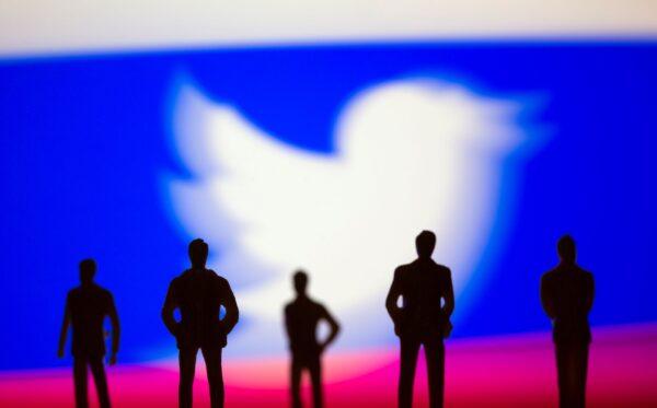 Small toy figures are seen in front of the Twitter logo and Russian flag colors in this illustration picture taken on March 15, 2021. (Dado Ruvic/Illustration/Reuters)