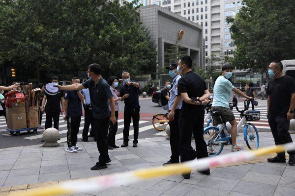 A police line is set up near a court where Zhou Xiaoxuan, also known by her online name Xianzi, attends a court session for a sexual harassment case involving a Chinese state TV host, in Beijing, China, on Sept. 14, 2021. (Tingshu Wang/Reuters)