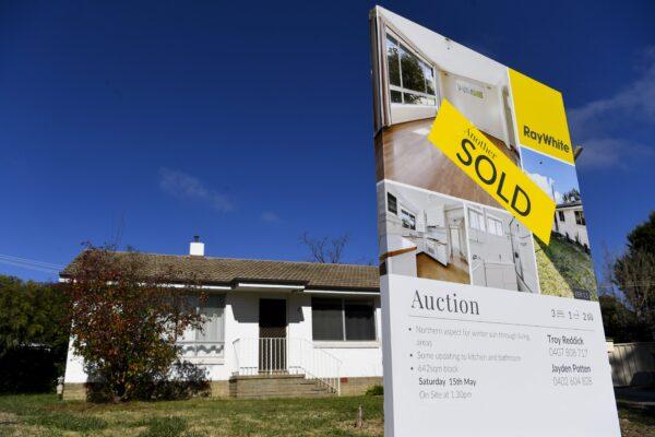 A ‘SOLD’ sticker is seen on a sale sign in front of a house in Canberra, Australia, May 18, 2021. (AAP Image/Lukas Coch)