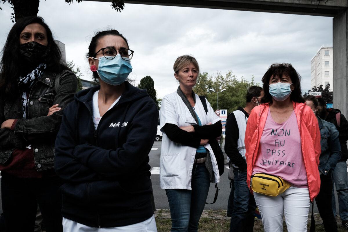 Hospital workers gather in protest of the health pass outside the CHU (University Hospital) Pellegrin where the health pass is mandatory in Bordeaux, southwestern France, on Aug. 9, 2021. (Philippe Lopez/AFP via Getty Images)